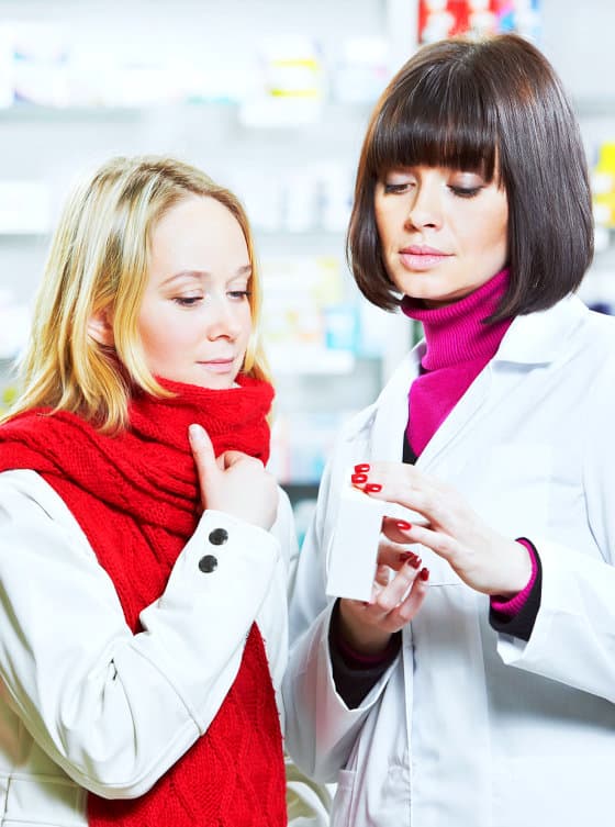 pharmacist showing medicine to woman